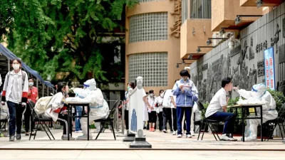 Медицинские работники берут мазки у студентов для тестирования на COVID-19 в Пекине 7 июня 2022 года. (Jade Gao/AFP via Getty Images)