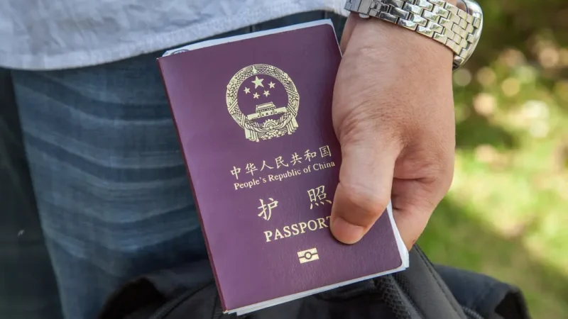 В Китае у низших чиновников начали отбирать паспорта Гражданин Китая держит в руках китайский паспорт. (Omar Havana/Getty Images)