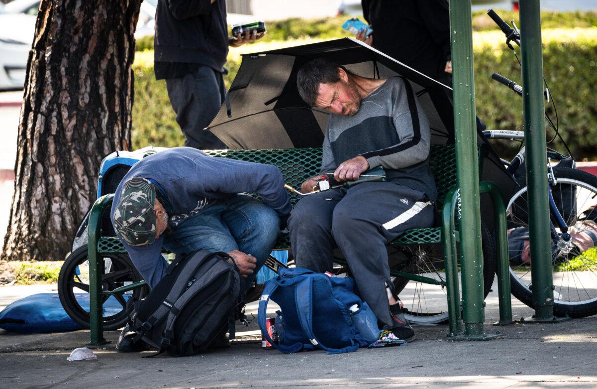 Бездомный мужчина держит в руках паяльную лампу, которой он нагревал фентанил в Гарден-Гроув, Калифорния, 3 апреля 2023 года. (John Fredricks/The Epoch Times) Преступность в Вашингтоне: что нужно знать