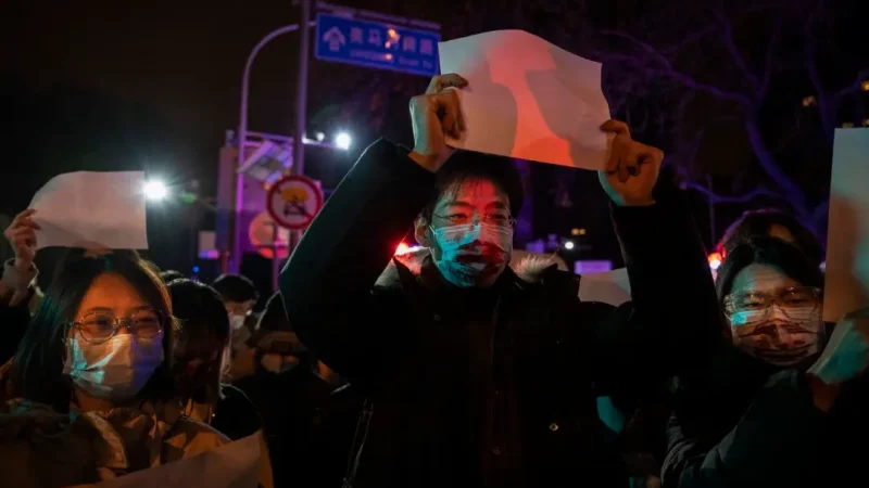 Компартия берёт на себя «общественную работу» в Китае Протестующие поднимают белый лист бумаги в знак протеста против цензуры во время акции против строгих мер по борьбе с COVID-19, в Пекине, 27 ноября 2022 года. (Kevin Frayer/Getty Images) | Epoch Times Россия