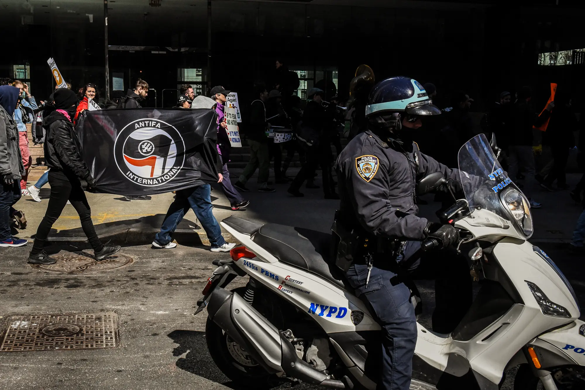 Люди держат флаг Антифа во время митинга в Нью-Йорке 16 марта 2019 года. Дональд Трамп заявил, что Антифа вербует молодых людей для участия в беспорядках, нападениях на полицию и препятствовании работе федеральных агентов, а также пытается подавить законные политические высказывания. (Stephanie Keith/Getty Images)