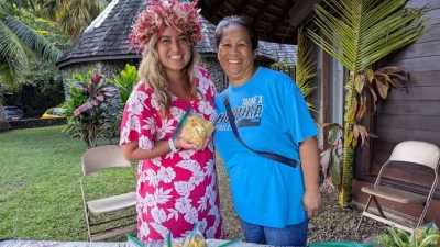 У одного из многочисленных продуктовых киосков вдоль кольцевого маршрута Мари-Жан Нордхофф (слева) покупает чипсы из хлебного дерева. (Courtesy of Athena Lucero)