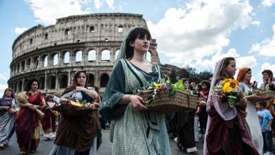 21 апреля 2013 года в Риме, Италия, актёры, одетые в костюмы древнеримских девушек, проходят перед Колизеем в памятном праздничном шествии, посвящённом 2766-й годовщине основания Рима.