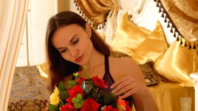 Девушка с букетом роз в интерьере, самый желанный подарок на 8 Марта по результатам опроса 2026 года.