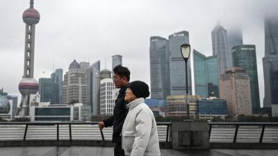 Люди прогуливаются по набережной Вайтань вдоль реки Хуанпу в Шанхае, 19 января 2026 года.