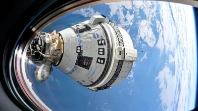 Космический корабль Boeing Starliner пристыкован к модулю Harmony МКС на фоне Земли, миссия с Бутчем Уилмором и Суни Уильямс.