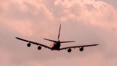 Взлет широкофюзеляжного пассажирского самолета в пасмурном небе, иллюстрация к новости о временном прекращении полетов в Иран и Израиль.