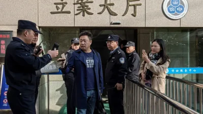 Адвокат Се Ян в окружении полиции у входа в здание суда в Китае