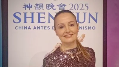 Г-жа Роэль, директор танцевальной школы, на фоне баннера шоу Shen Yun