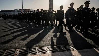 Китайские военные и чиновники в форме идут по площади в Пекине