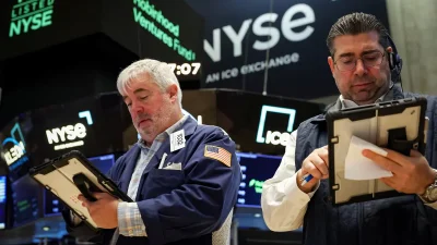 Трейдеры на Нью-Йоркской фондовой бирже следят за котировками на планшетах.