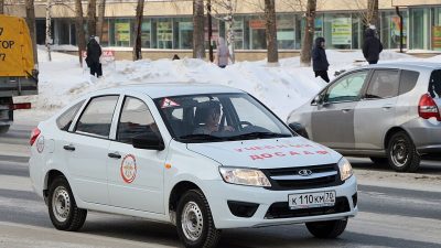 Учебный автомобиль Lada Granta с маркировкой автошколы на улице
