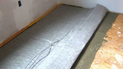 Монтаж сетчатого нагревательного мата на клеевой раствор для системы теплого пола в ванной комнате.