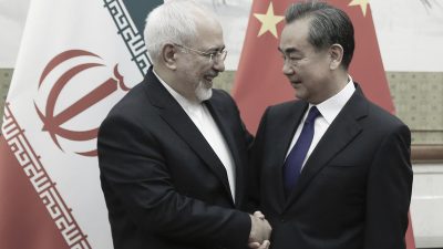 Рукопожатие министра иностранных дел Китая Ван И и министра иностранных дел Ирана Мохаммада Джавада Зарифа на фоне государственных флагов в Пекине.