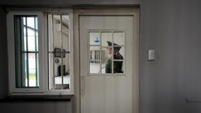 Охранник стоит у двери с кодовым замком в Центре заключения №1 во время экскурсии для представителей правительства в Пекине, 25 октября 2012 года.