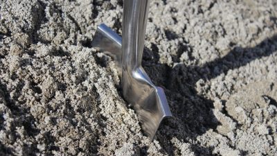 Металлическая лопата в земле — иллюстрация к новости о жителе Индии, который выкопал останки сестры для банка.