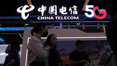 Светящаяся вывеска China Telecom 5G и люди в масках на переднем плане