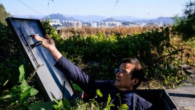 Владелец открывает люк частного подземного бункера на загородном участке