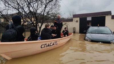 Лодка с людьми и затопленный автомобиль на улице в Дагестане
