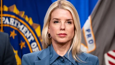 Пэм Бонди на фоне флага Министерства юстиции США