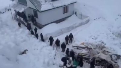 Группа людей разгребает глубокий снег и обломки дома в Дагестане после лавины