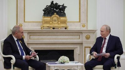 Президент России Владимир Путин и премьер-министр Армении Никол Пашинян сидят в креслах у камина во время официальной встречи в Кремле