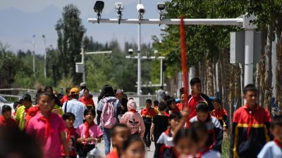 Школьники идут под камерами наблюдения в городе Акту на западе китайского региона Синьцзян, 4 июня 2019 года.