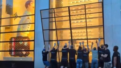 Установка защитной панели на витрину магазина перед матчем ПСЖ и «Арсенала»