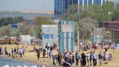 Люди гуляют по песчаному берегу Черного моря в Анапе