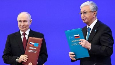 Владимир Путин и Касым-Жомарт Токаев держат папки с подписанными документами о строительстве АЭС