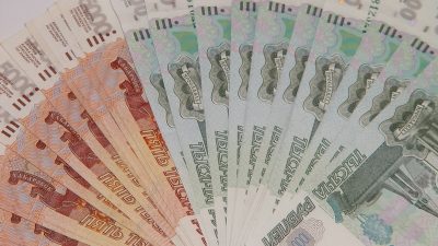 Купюры российских рублей номиналом 1000 и 5000 рублей веером как символ планируемых страховых выплат военным пенсионерам.