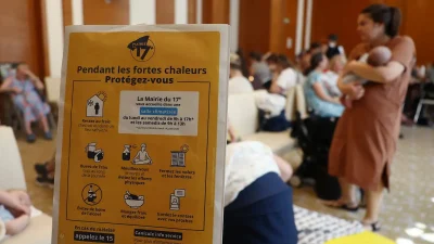 Табличка с надписью «Во время сильной жары берегите себя» в помещении с кондиционером, открытом для посетителей в мэрии 17-го округа Парижа, 25 июня 2026 года.