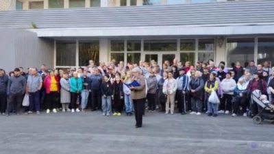 Толпа беженцев собралась у входа в здание ПВР во время записи официального обращения к властям.