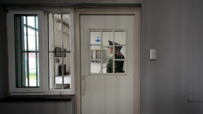 Охранник стоит у двери с кодовым замком в Центре заключения №1 во время экскурсии с гидом в Пекине, 25 октября 2012 года.