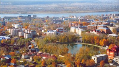 Панорама города у реки в Тюменской области, развитие термального туризма и курортов.