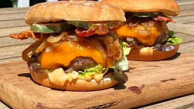 Два аппетитных бургера с сыром, беконом и карамелизированным луком