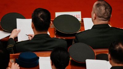 Делегаты зачитывают документы во время пленарного заседания Всекитайского собрания народных представителей в Пекине 9 марта 2026 года.