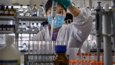 Техник работает в лаборатории компании Sinovac Biotech, где производится вакцина от COVID-19 CoronaVac, во время пресс-тура в Пекине 24 сентября 2020 года.
