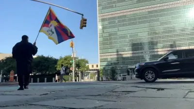 Мужчина, которого издание Voice of Tibet, представляющее интересы тибетцев в изгнании, называет тибетским активистом Лобгой Рангценом, идёт с тибетским флагом возле штаб-квартиры ООН, а затем поджигает себя в знак протеста за независимость Тибета. Снимок сделан 2 июля 2026 года.