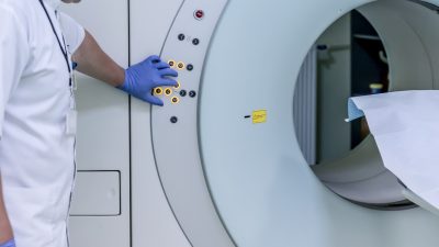 Врач проводит медицинское обследование пациента на томографе в центре здорового долголетия.
