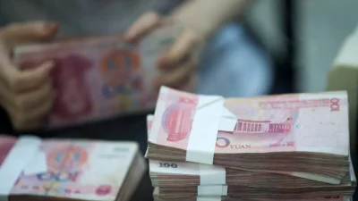 Сотрудница банковского отделения пересчитывает деньги, обслуживая клиента в пилотной зоне свободной торговли в Китае (Шанхай) во время пресс-тура 24 сентября 2014 года.