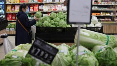 Покупательница выбирает капусту в пекинском супермаркете, 17 октября 2024 года.