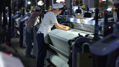 Сотрудники работают на производственной линии компании Anhui Jingjiu Silk в городе Фуян, провинция Аньхой на востоке Китая, 20 октября 2025 года.