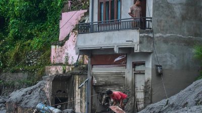 Мужчина убирает обломки после внезапного наводнения в Девигхате, округ Нувакот, Непал, 27 августа 2026 года.