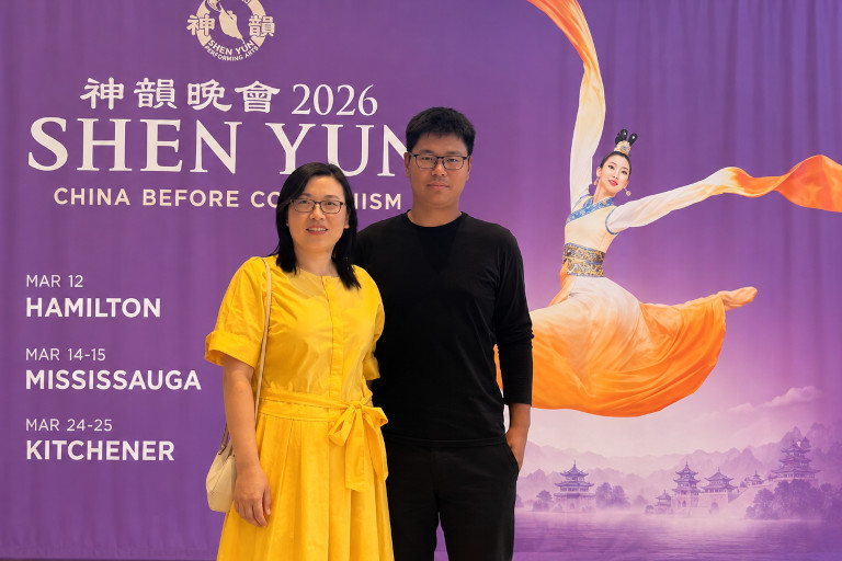 Супруги из Китая на фоне плаката Shen Yun в Канаде
