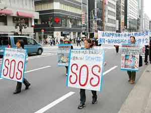 SOS. Суцзятунь!!! Колонна движется по улицам Киото. Фото: The Epoch Times